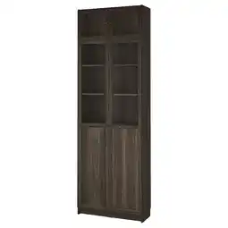 IKEA Een hoge, donkerbruine billy boekenkast met glazen deuren. Het heeft meerdere planken voor opslag aanbieding